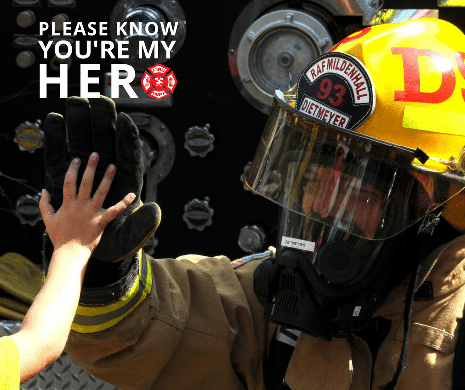 Firefighter hi-fiving a child
