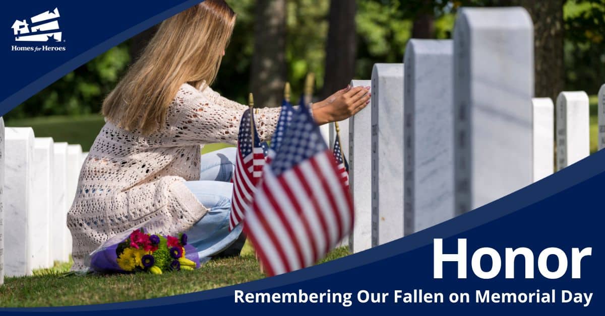 woman at fallen military family member grave kneeling holding stone with flowers us flags on memorial day Homes for Heroes