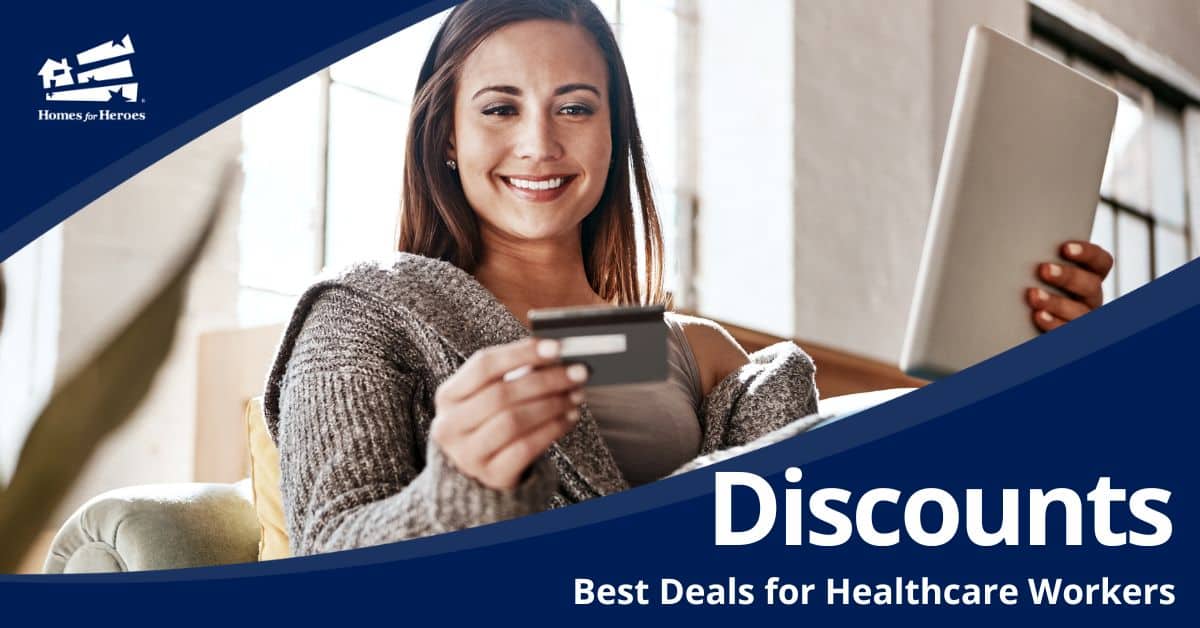 young woman sitting on couch holding credit card and laptop taking advantage of healthcare worker discounts online Homes for Heroes