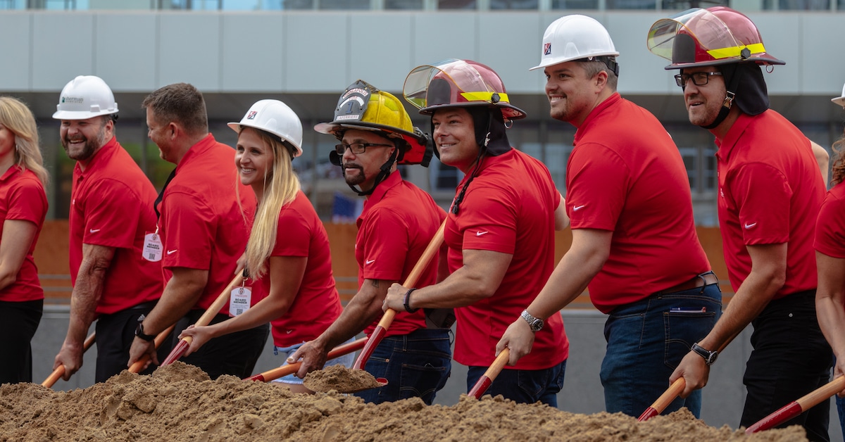 Firefighters for Healing Transitional Healing Center ground breaking ceremony volunteers red shirts lined up with shovels dirt
