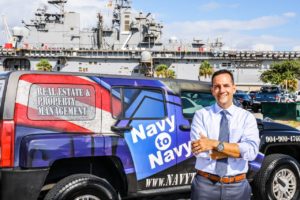 Navy to Navy's Mario Gonzalez poses next to his company branded truck