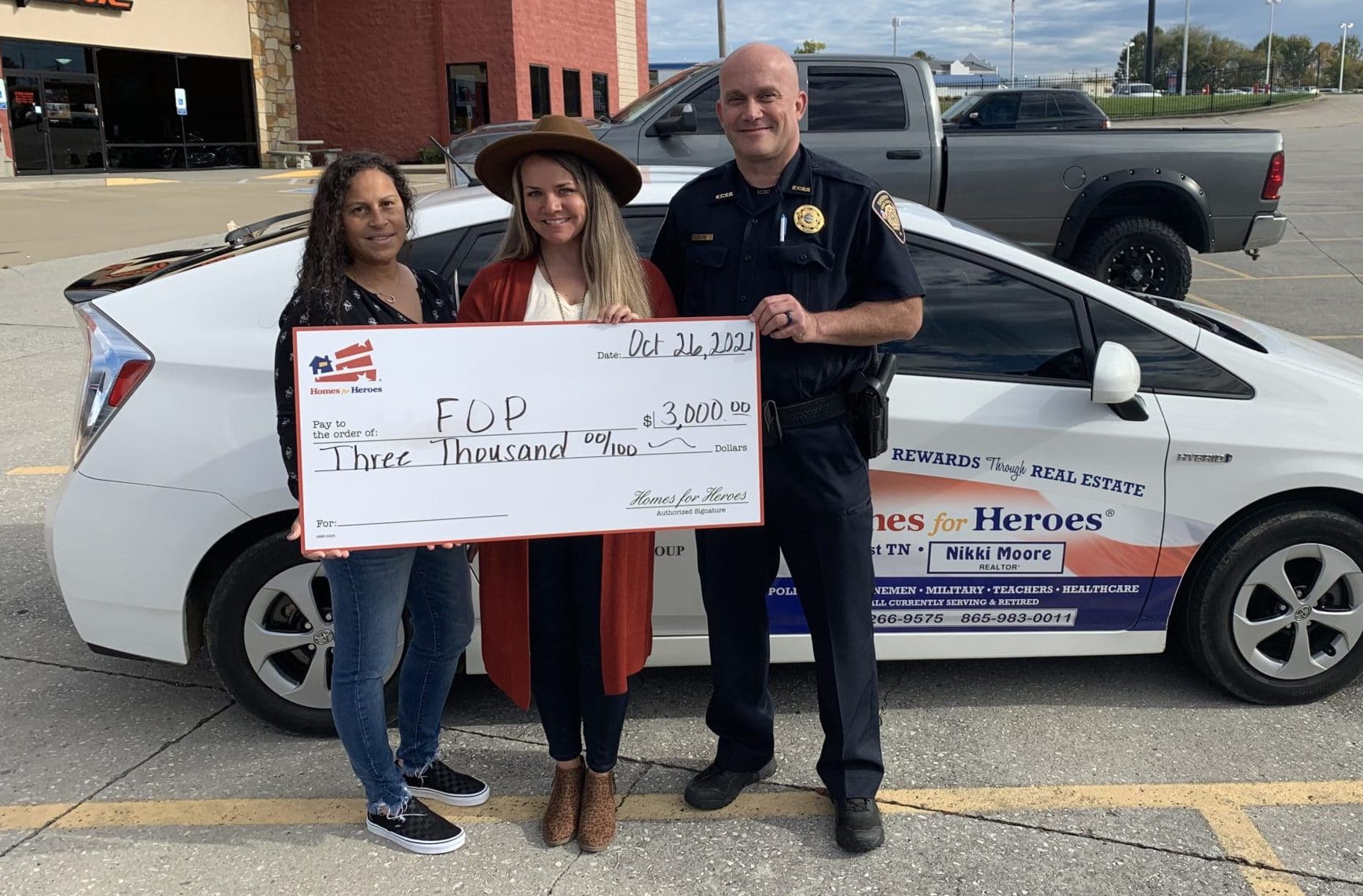 Real Estate Specialist Nikki Moore presents a giant check for $3,000 to Knoxville FOP President Keith Lyon from the Homes for Heroes Foundation in honor of 50,000 heroes served