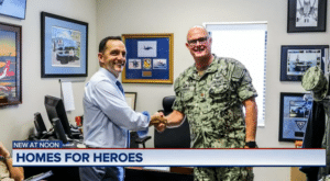 Homes for Heroes real estate agent Mario Gonzales shakes hands for a picture with a member of the United States Military in his office in Florida.