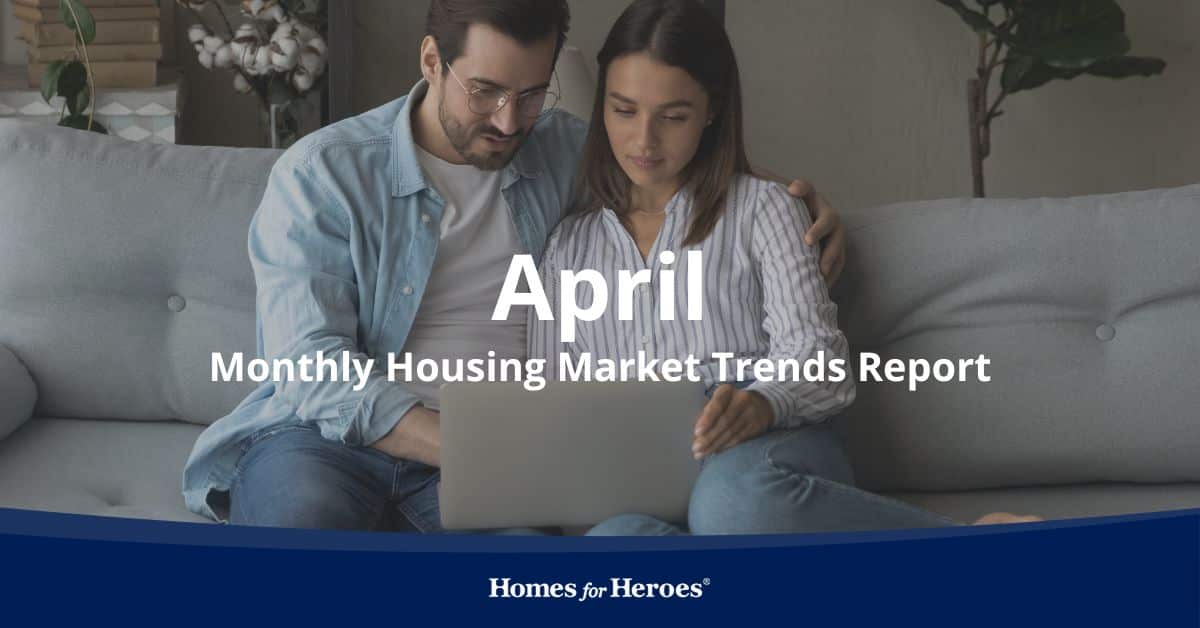 married couple sitting on couch in home looking at laptop discussing housing market trends April 2024 Homes for Heroes