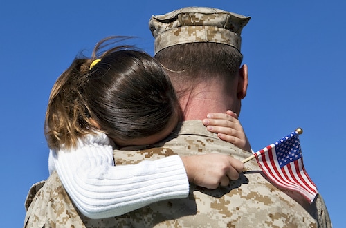 /wp-content/uploads/2022/07/military-man-father-hugging-girl-daughter-holding-small-american-flag.jpg