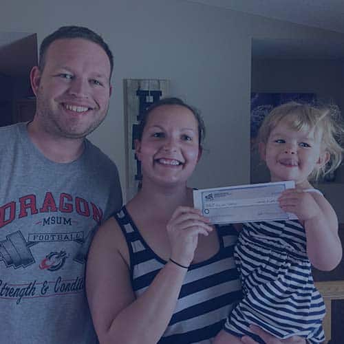 firefighter family father mother holding child with Homes for Heroes Hero Rewards Savings check
