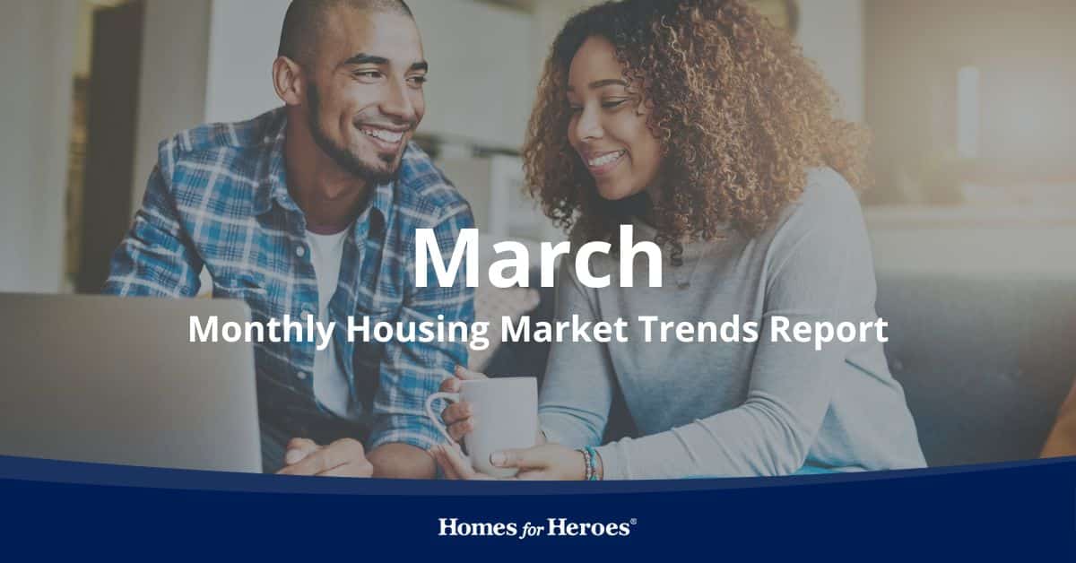 couple sitting on couch smiling holding tea discussing housing market trends March 2024 Homes for Heroes