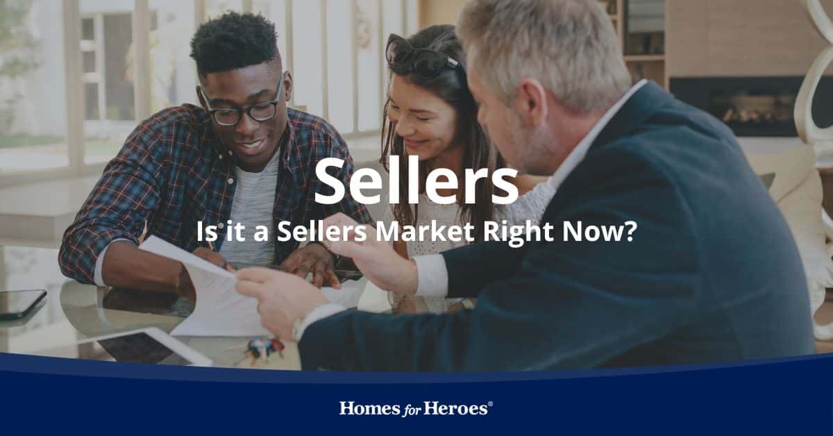 couple sitting at desk going through agent market analysis discussing whether it is a sellers market right now Homes for Heroes