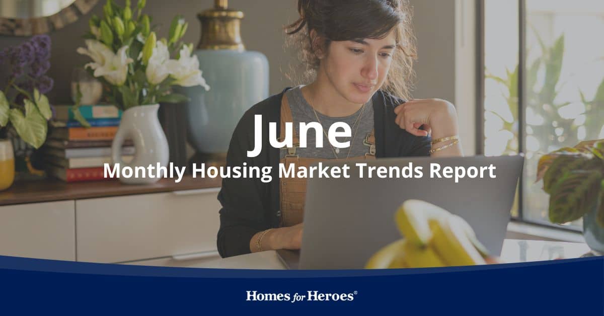 young woman sitting at table researching the Housing Market Trends June 2023 on her laptop from Homes for Heroes