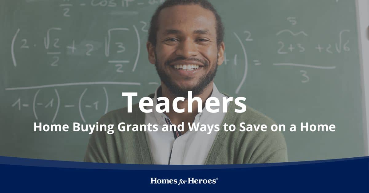 male teacher standing in front of chalkboard with equations smiling after discussing teacher home buying grants Homes for Heroes