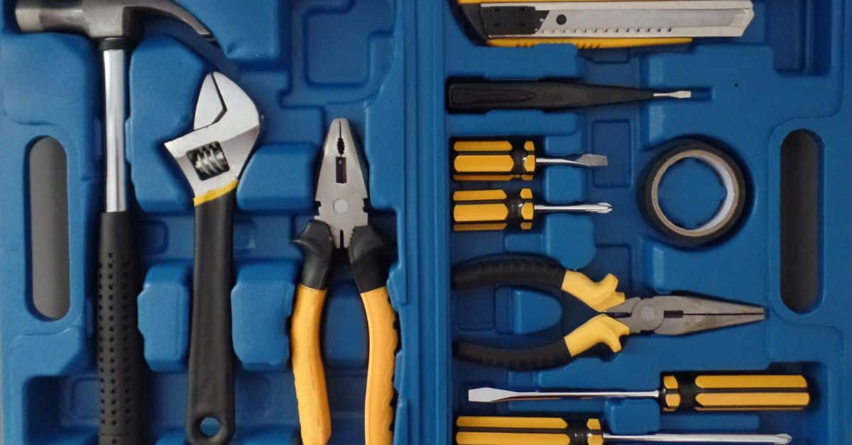 blue toolbox case filled with hammer pliers screwdrivers box cutter and tape