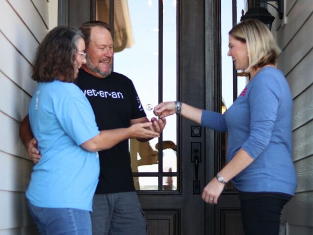 Veteran homebuyer receives keys to new house from real estate specialist