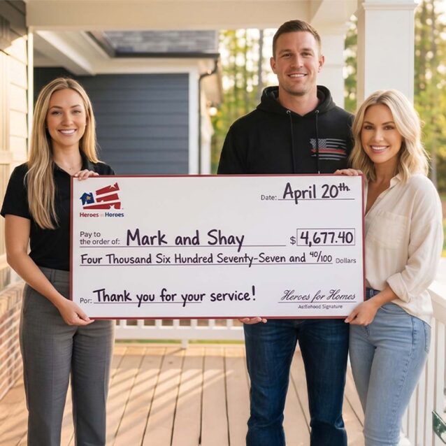 Affiliate specialist Maya standing on a porch with Mark and Shay as they hold a giant Hero Rewards check for $4,677.40 from the Homes for Heroes program.